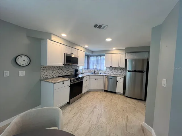 a kitchen with a refrigerator sink and cabinets