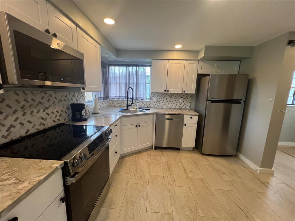 129 Northshore Terrace Punta Gorda, FL 33980 - Photo 9 of 37 a kitchen with stainless steel appliances granite countertop a stove a sink and a refrigerator