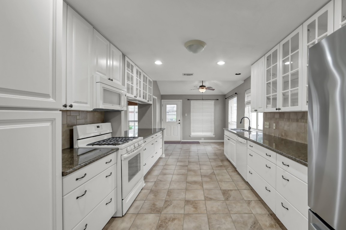 16135 Ridge Park Drive Houston, TX 77095 - Photo 14 of 27 a large kitchen with stainless steel appliances a stove a sink and a white cabinets