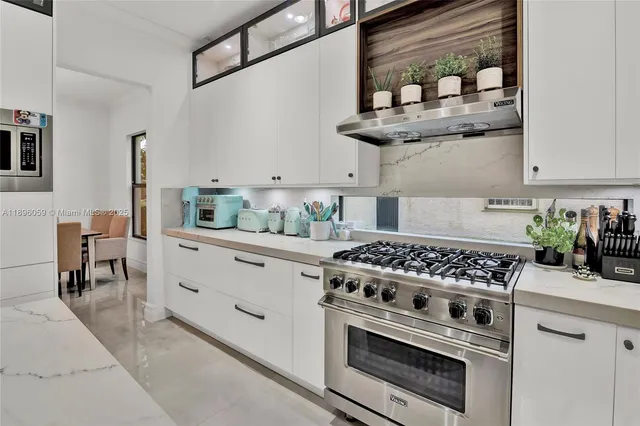 a kitchen with stainless steel appliances granite countertop white cabinets and a stove