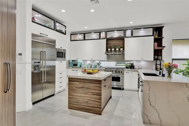 a kitchen with stainless steel appliances a refrigerator sink and cabinets