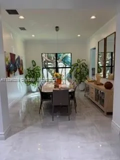a dining room with furniture and a potted plant
