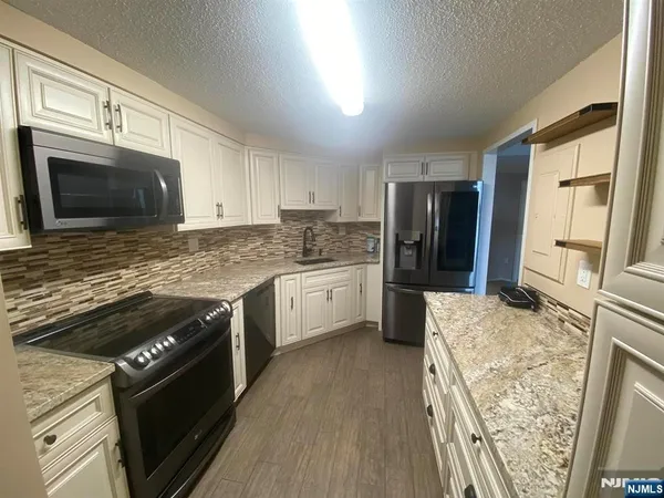 a kitchen with a stove a sink and a microwave