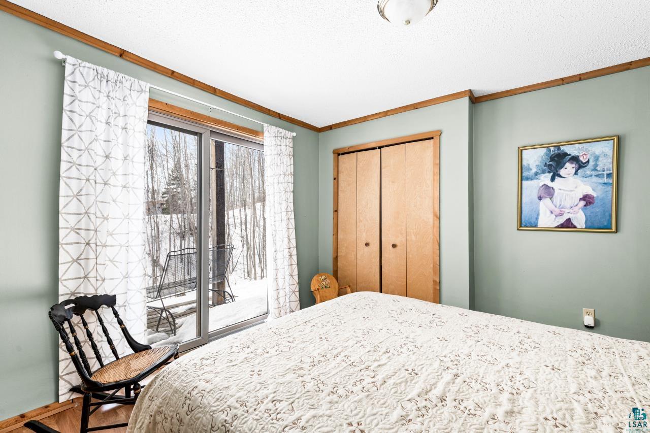 67 Snowshoe Trail Tofte, MN 55615 - Photo 35 of 42 Bedroom featuring crown molding, a closet, and access to outside