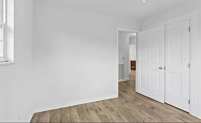 a view of an empty room with wooden floor