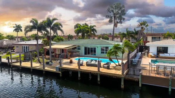 an aerial view of a house with a swimming pool patio and outdoor seating