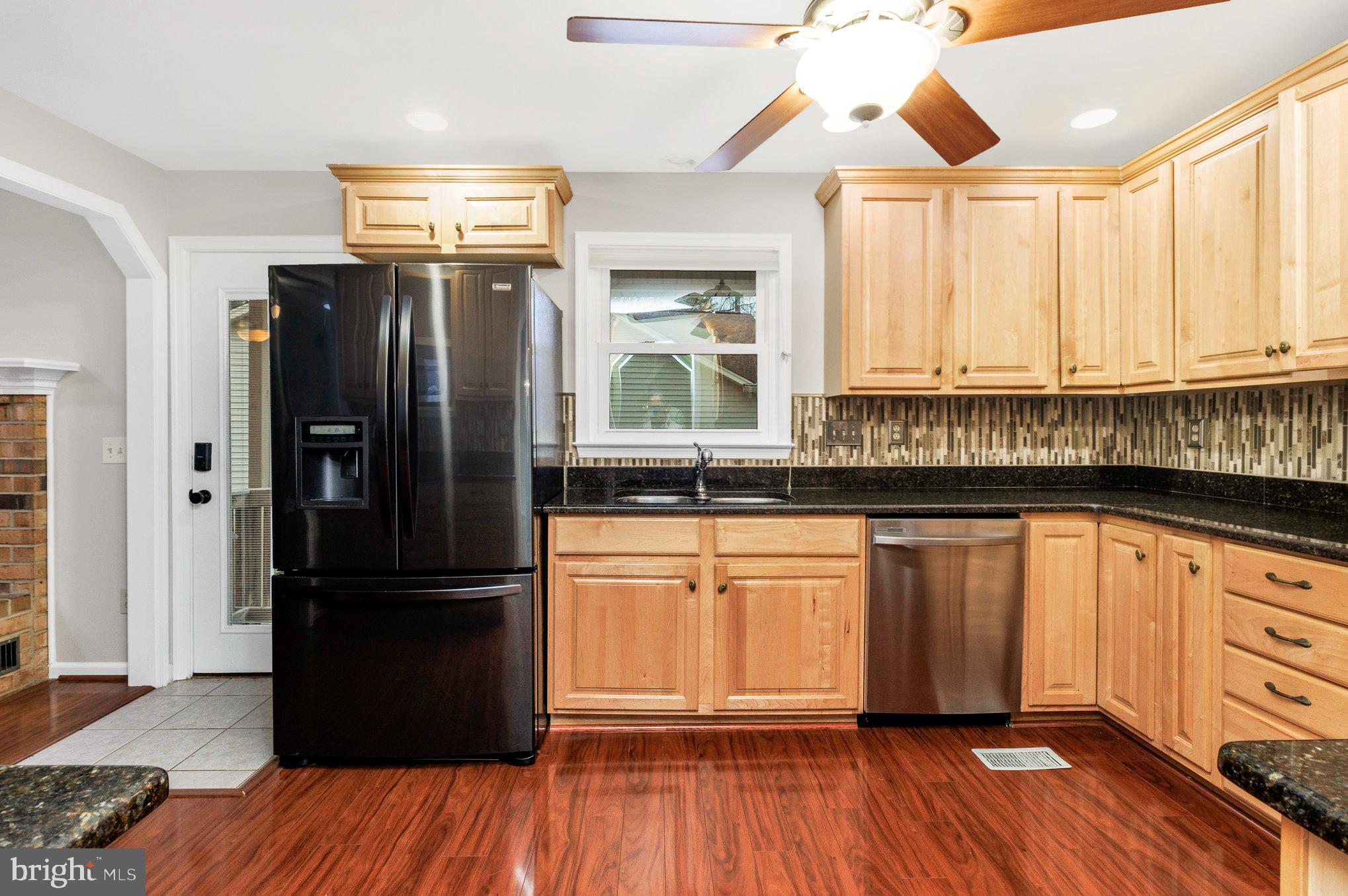 205 Fairway Drive Locust Grove, VA 22508 - Photo 15 of 26 a kitchen with granite countertop stainless steel appliances a refrigerator cabinets and wooden floor
