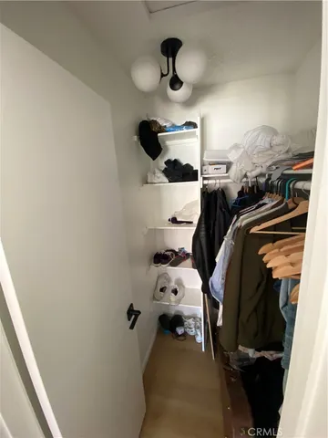 a view of walk in closet with clothes and shoes