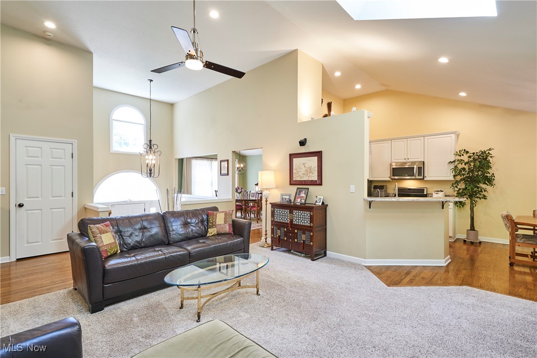 4535 Pinewood Path Akron, OH 44321 - Photo 6 of 27 Carpeted living area with high vaulted ceiling, wood finished floors, ceiling fan, recessed lighting, and a skylight