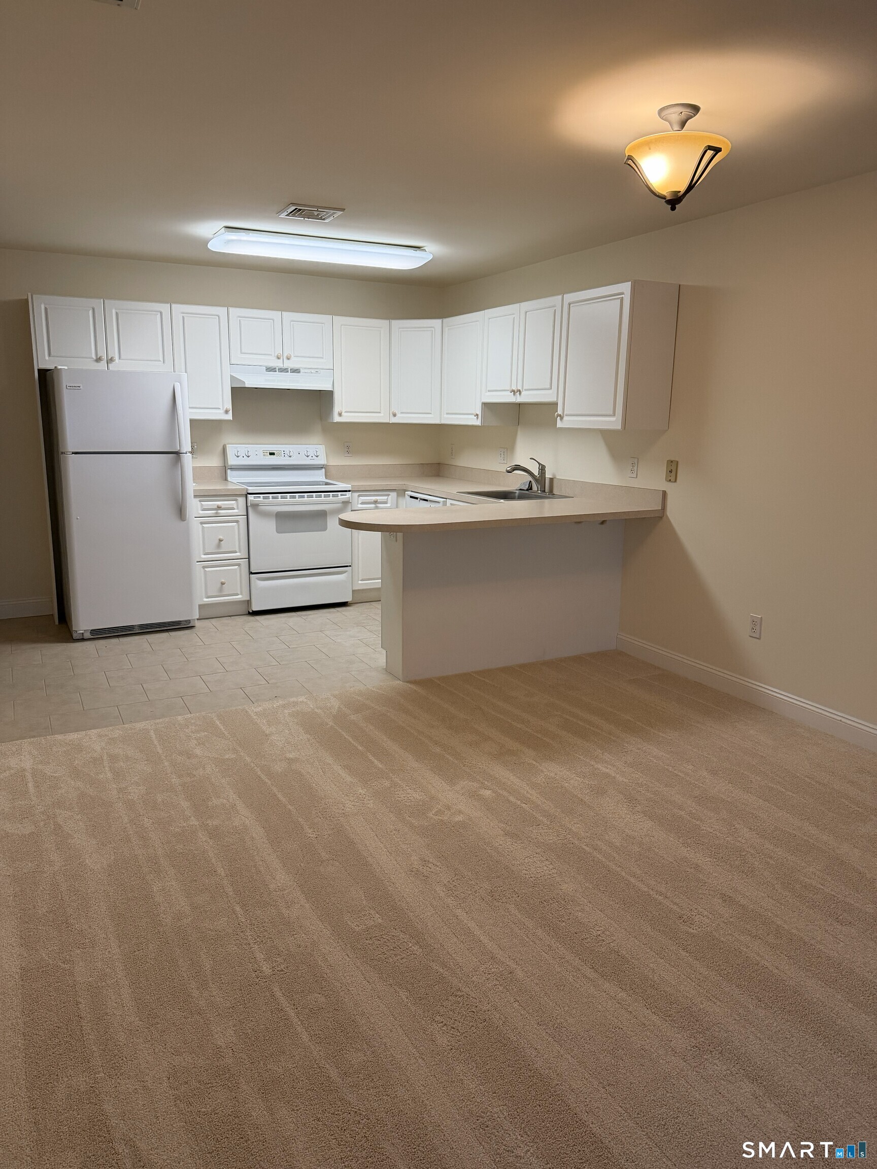 365 Westport Avenue, Unit 2B Norwalk, CT 06851 - Photo 11 of 19 a kitchen with a refrigerator sink and white cabinets