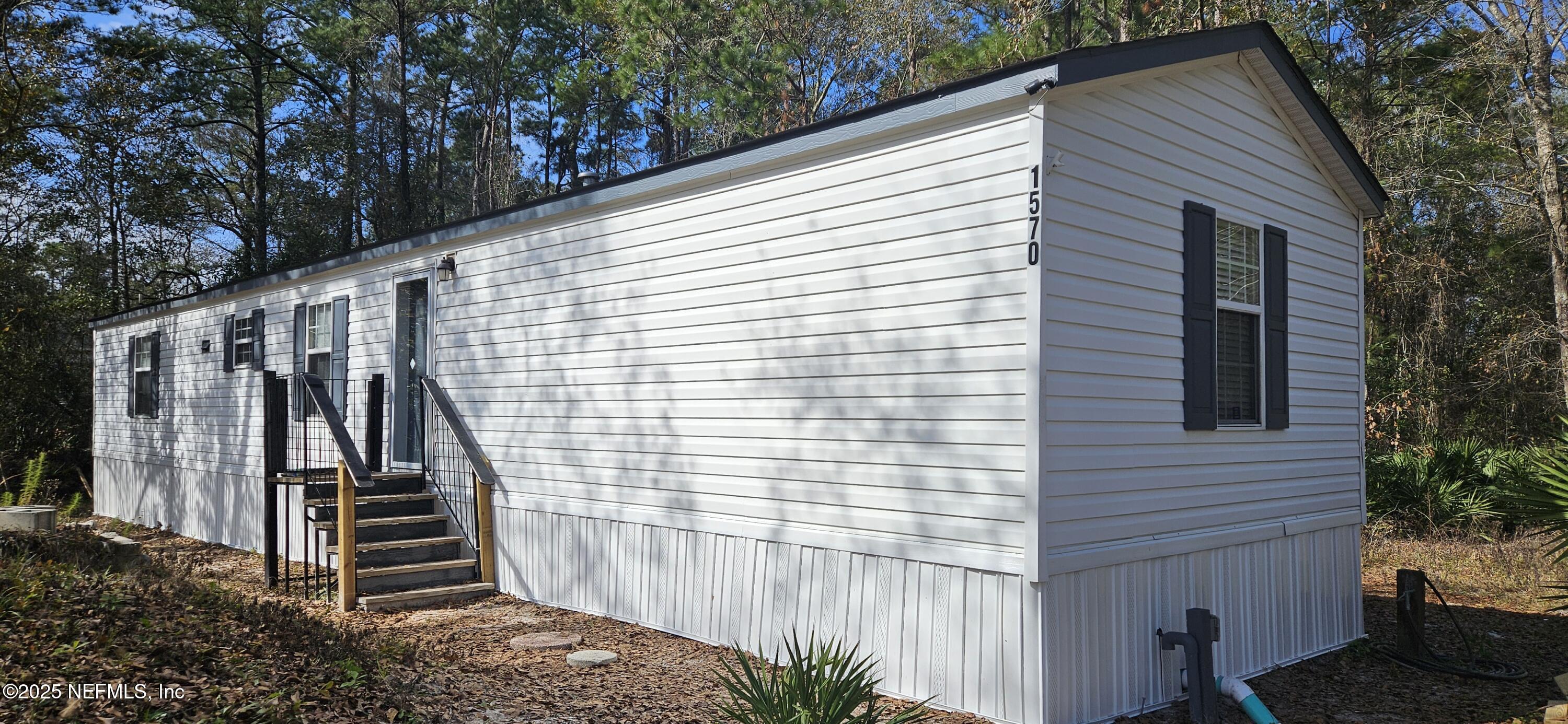 1570 Bluejay Drive Middleburg, FL 32068 - Photo 2 of 17 a view of a wooden house with a large window and wooden fence