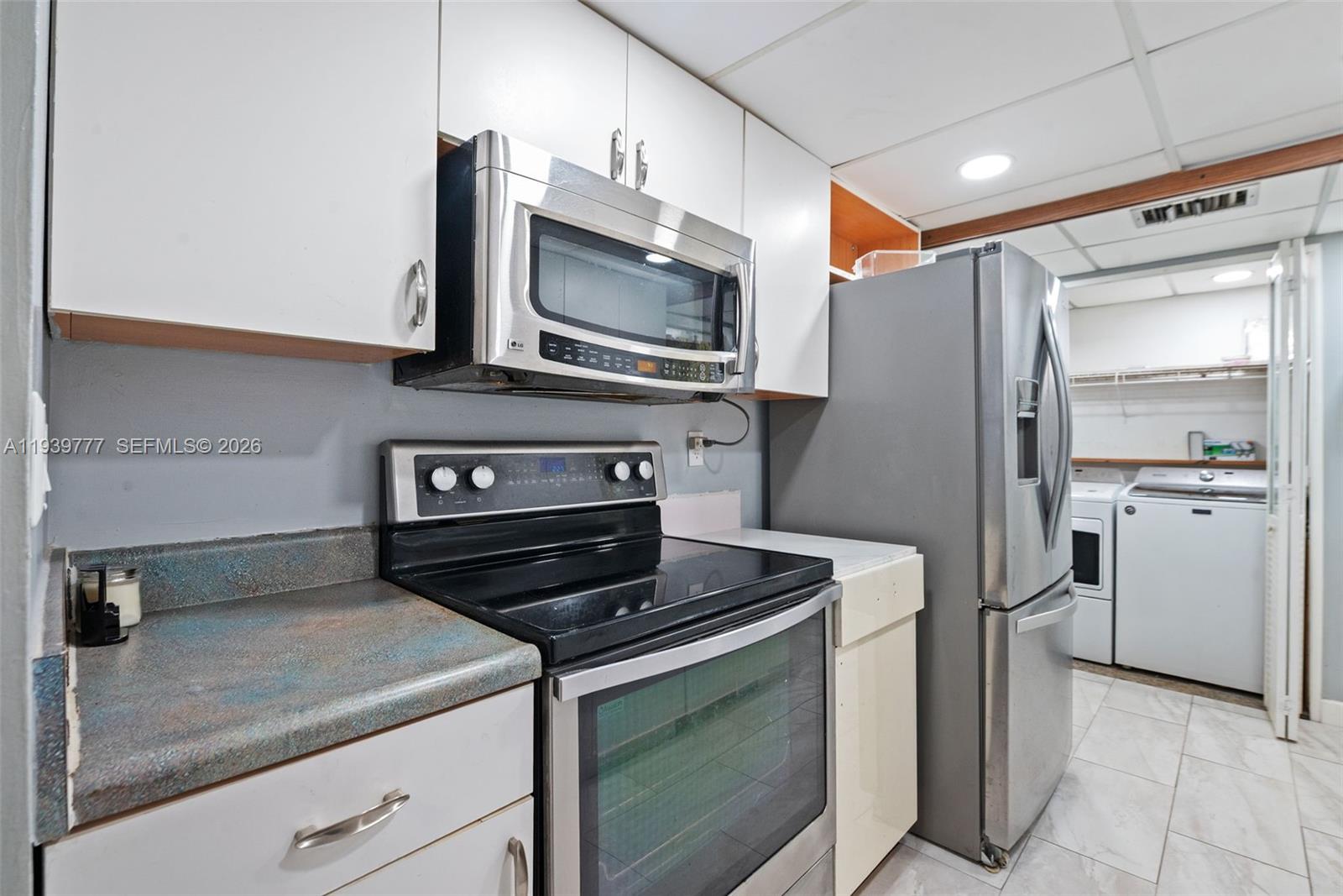 8001 Northwest 68th Terrace Tamarac, FL 33321 - Photo 12 of 27 a kitchen with white cabinets and stainless steel appliances