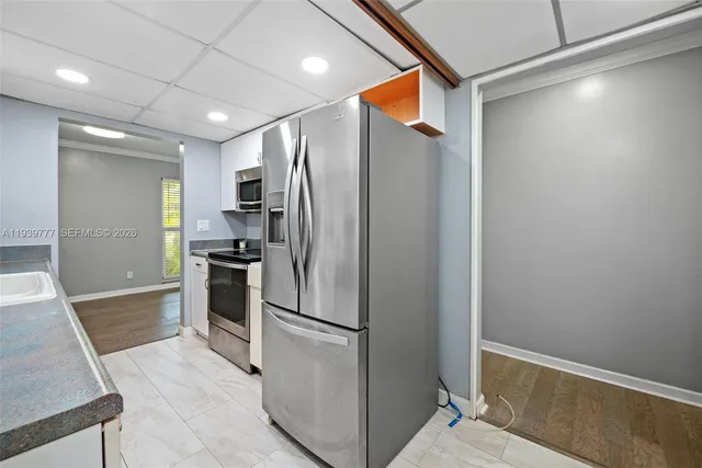 a metallic refrigerator freezer and a stove sitting inside of a kitchen