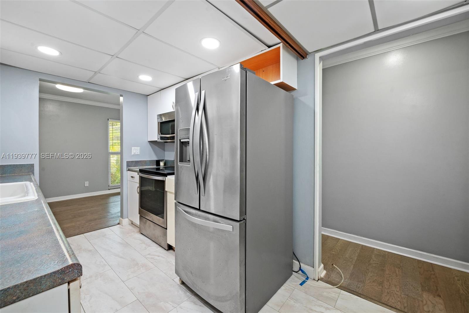 8001 Northwest 68th Terrace Tamarac, FL 33321 - Photo 13 of 27 a metallic refrigerator freezer and a stove sitting inside of a kitchen