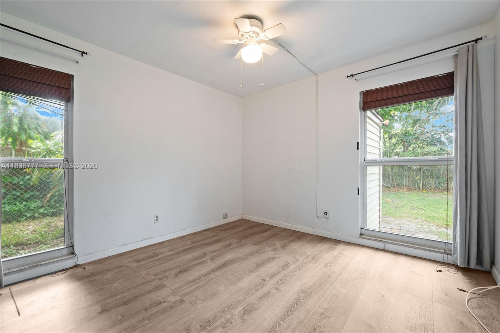 8001 Northwest 68th Terrace Tamarac, FL 33321 - Photo 15 of 27 a view of empty room with wooden floor and fan