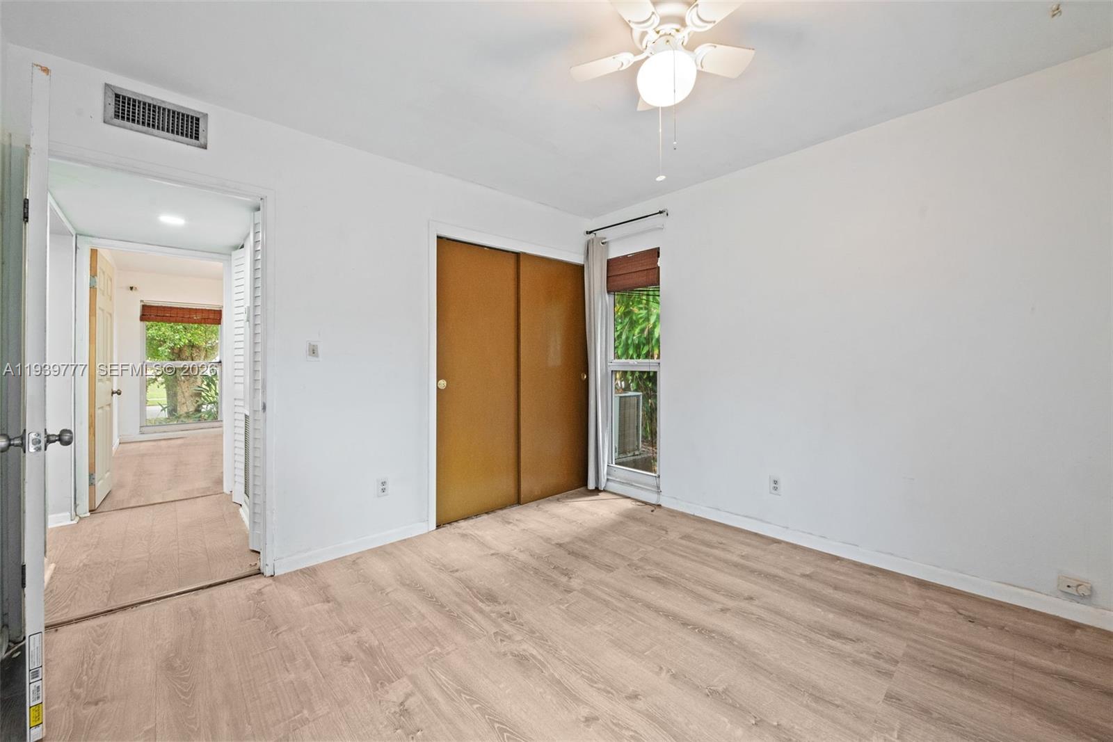 8001 Northwest 68th Terrace Tamarac, FL 33321 - Photo 16 of 27 an empty room with a chandelier fan and windows