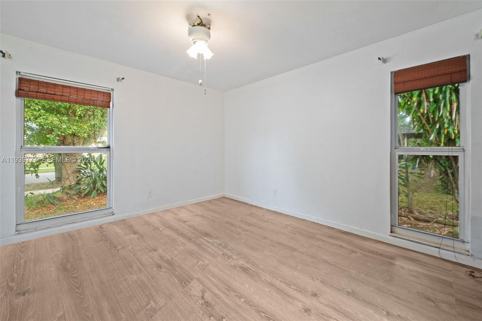 8001 Northwest 68th Terrace Tamarac, FL 33321 - Photo 18 of 27 a view of an empty room with wooden floor and a window
