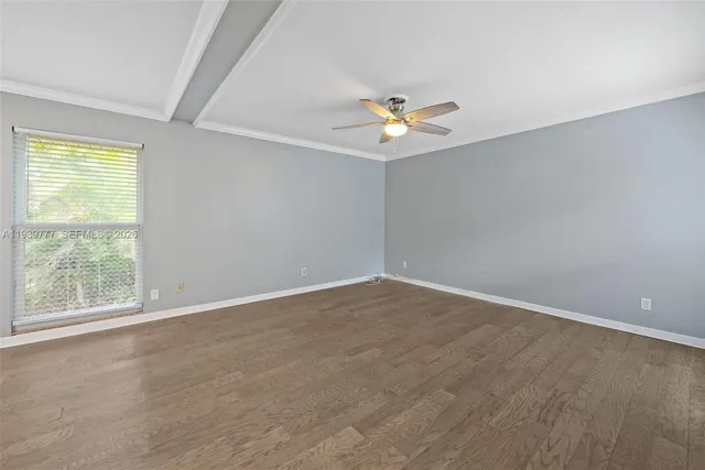 an empty room with a window and a ceiling fan