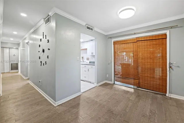 an empty room with large window and wooden floor
