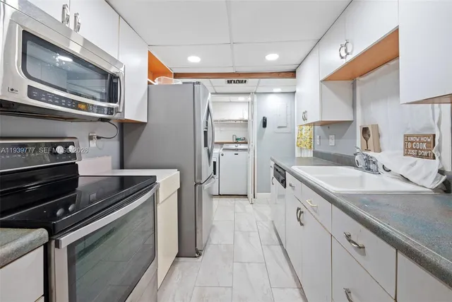 a kitchen with refrigerator cabinets and a sink