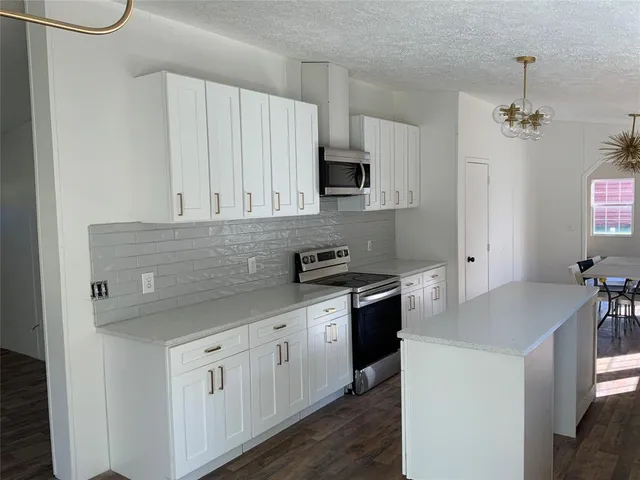 a kitchen with stainless steel appliances white cabinets and a sink
