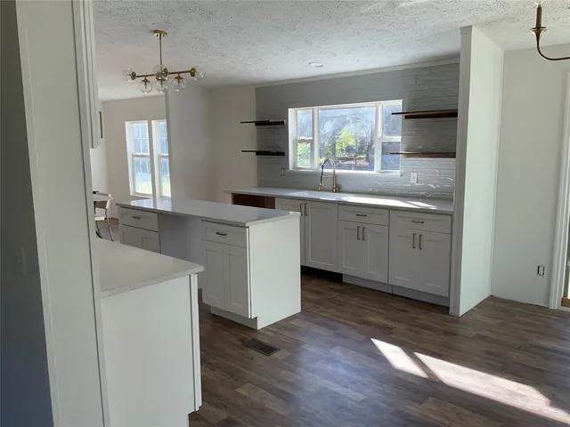 a kitchen with sink cabinets and wooden floor