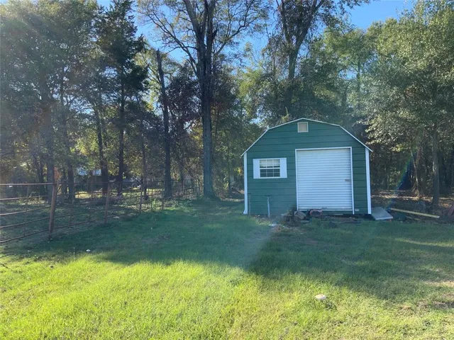 a view of a yard in front of a house with large trees
