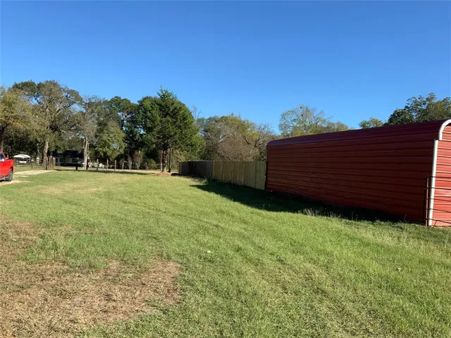 a view of a backyard with wooden fence