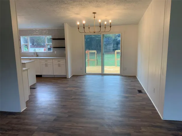 a view of a kitchen with a fridge wooden floor and a kitchen