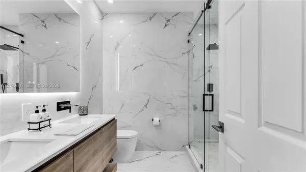 a bathroom with a sink a toilet and a mirror