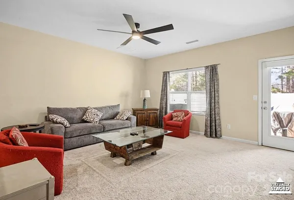 a living room with furniture a ceiling fan and a window