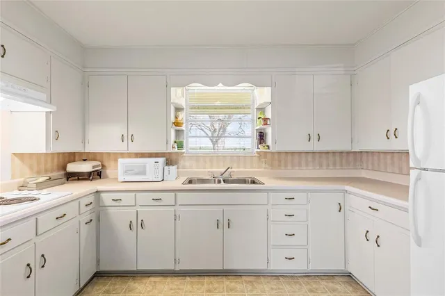 a kitchen with white cabinets sink and white appliances