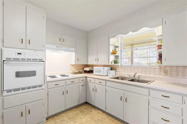 a kitchen that has a lot of cabinets in it and appliances