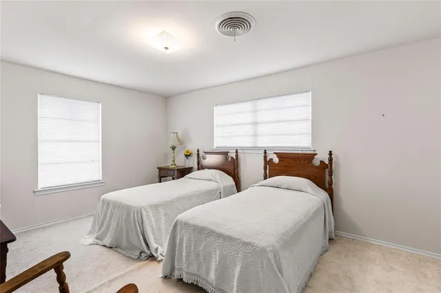 a bedroom with a bed and a dresser next to a window