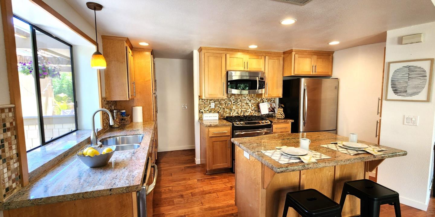 14566 South Bascom Avenue Los Gatos, CA 95032 - Photo 8 of 28 a kitchen with stainless steel appliances granite countertop a refrigerator a stove top oven a dining table and chairs