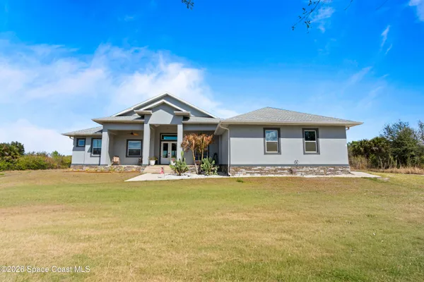 a front view of a house with swimming pool having outdoor seating