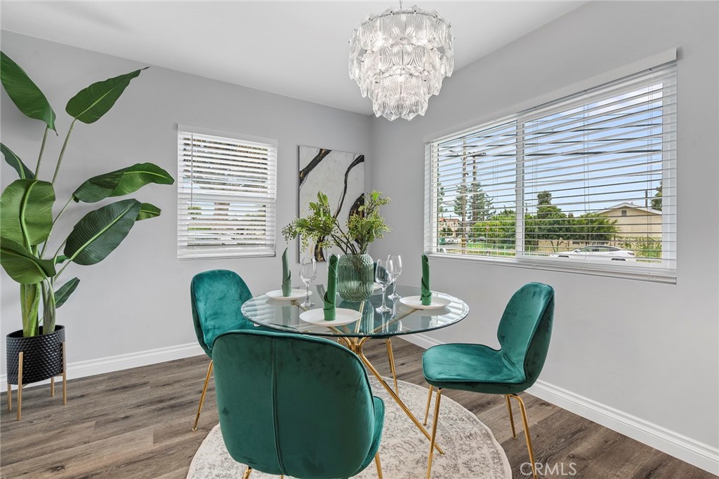 9131 Hall Road Downey, CA 90241 - Photo 12 of 32 a dining room with furniture potted plants and wooden floor
