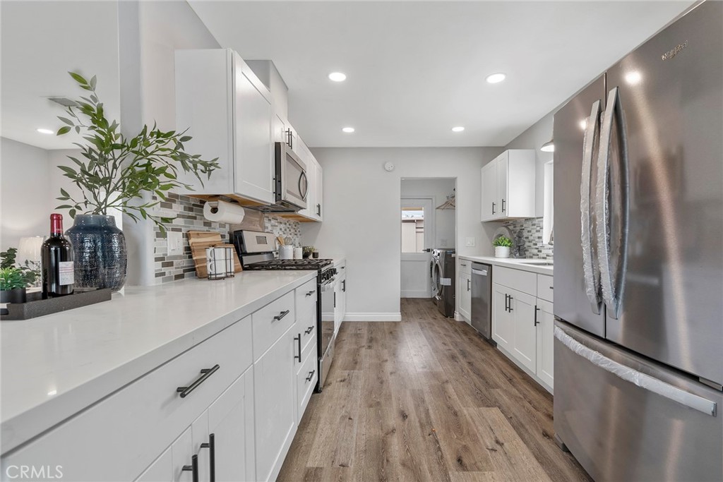 9131 Hall Road Downey, CA 90241 - Photo 15 of 32 a kitchen with stainless steel appliances a refrigerator sink and wooden floor