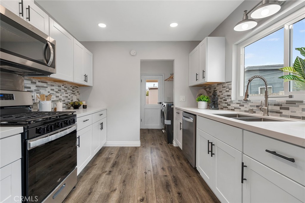 9131 Hall Road Downey, CA 90241 - Photo 16 of 32 a kitchen with stainless steel appliances granite countertop wooden cabinets stove top oven and sink