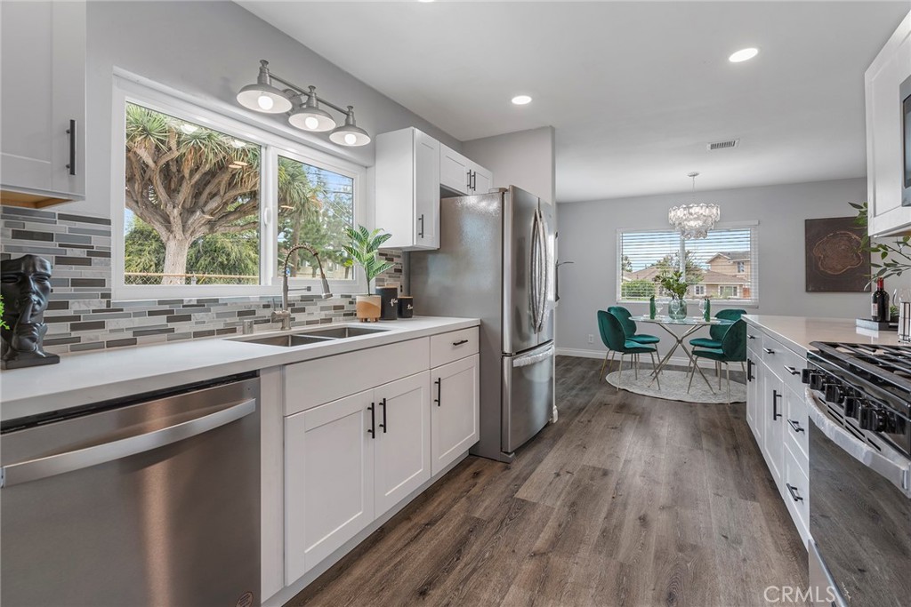 9131 Hall Road Downey, CA 90241 - Photo 17 of 32 a kitchen with stainless steel appliances a sink cabinets wooden floor and a large window