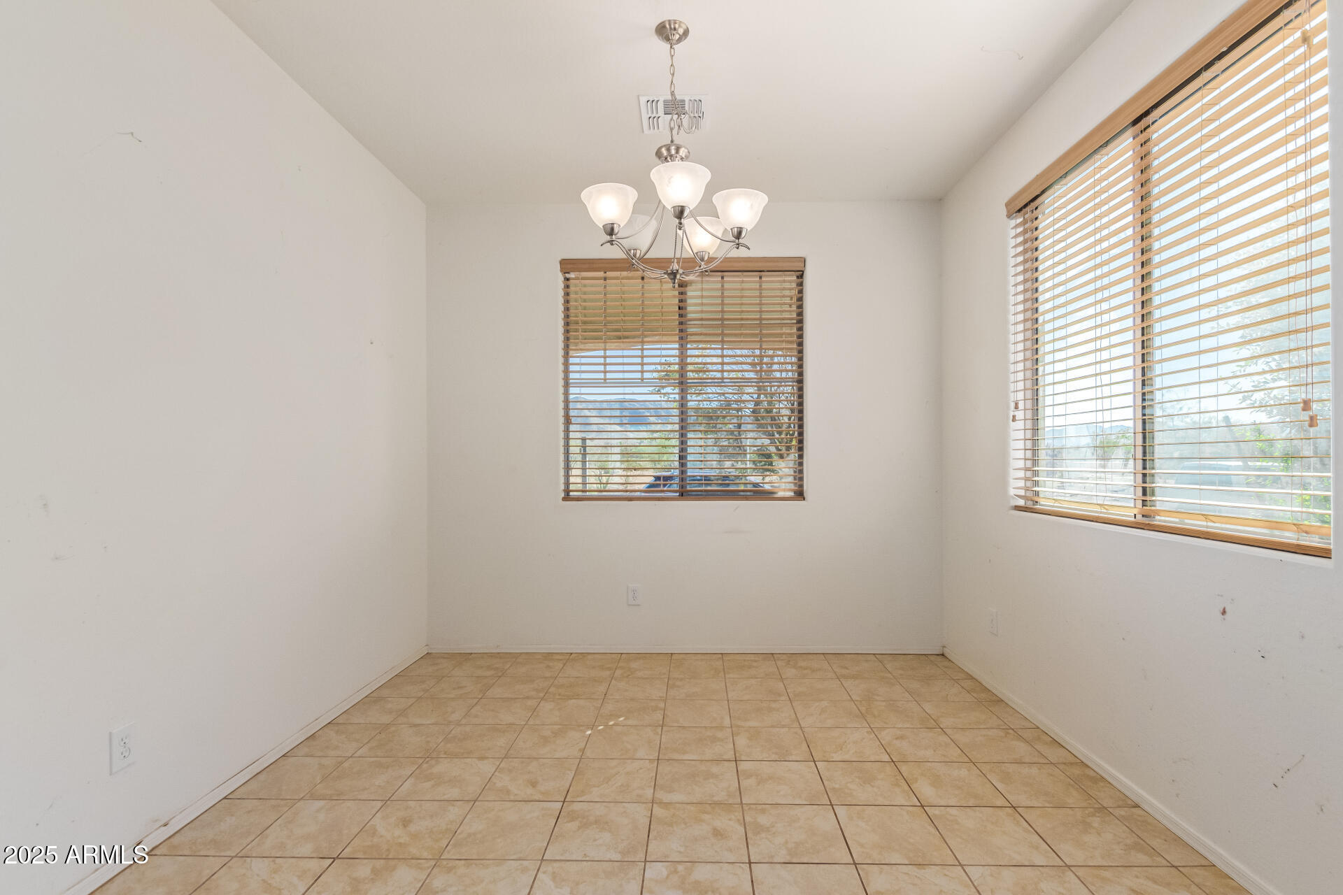 2536 West Gary Way Phoenix, AZ 85041 - Photo 7 of 26 an empty room with windows and chandelier