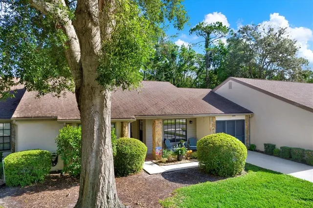 an aerial view of a house with a yard and a large tree