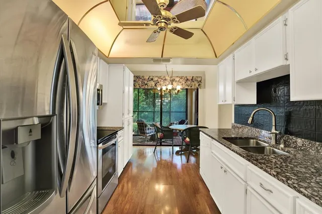 a kitchen with granite countertop a sink appliances cabinets and furniture