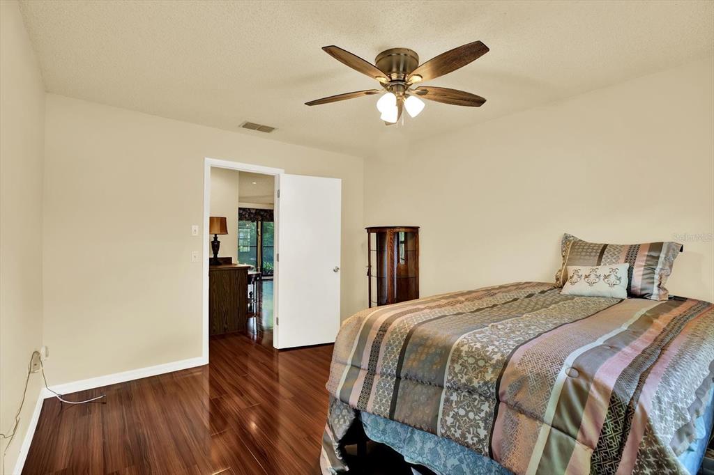 6654 Brambleleaf Drive Spring Hill, FL 34606 - Photo 10 of 27 a bedroom with a bed and a chandelier