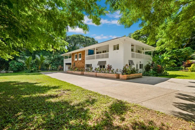 a view of a house with backyard and sitting area