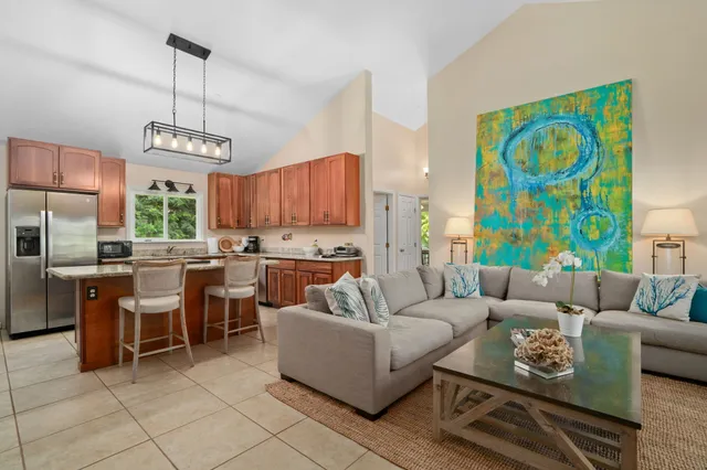 a living room with furniture a dining table and a floor to ceiling window