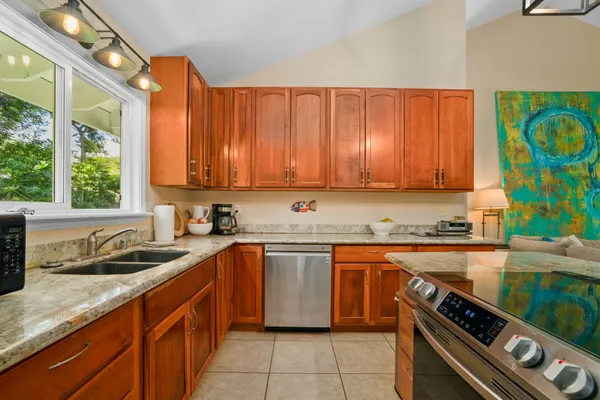 a kitchen with a sink a stove cabinets and a window