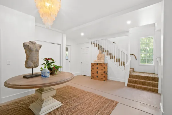 a room with lots of white furniture and entryway