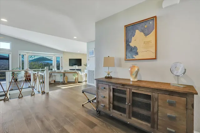 a kitchen with kitchen island granite countertop a stove a sink a refrigerator and a dining table with wooden floor