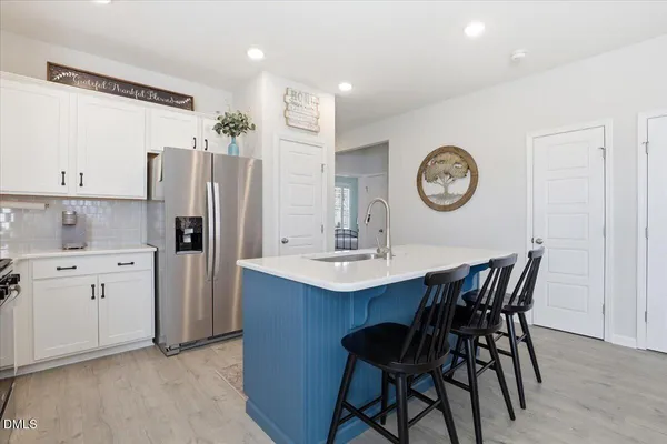 a kitchen with stainless steel appliances a table chairs and a refrigerator